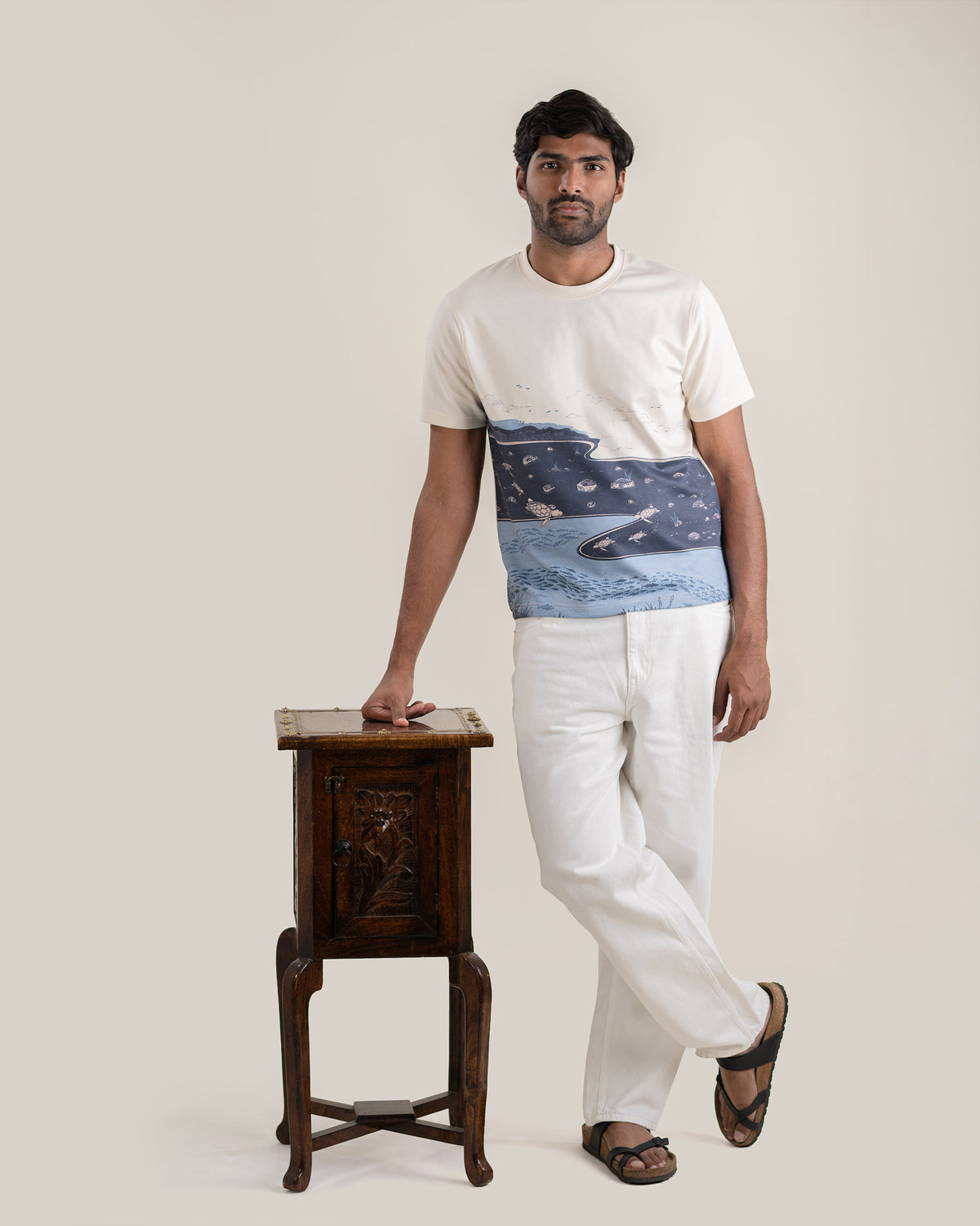 Full length view of the Makara Tee worn with trousers.